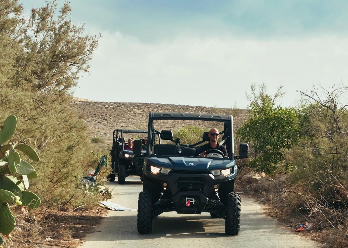 Gozo UTV convoy with limestone hills behind.